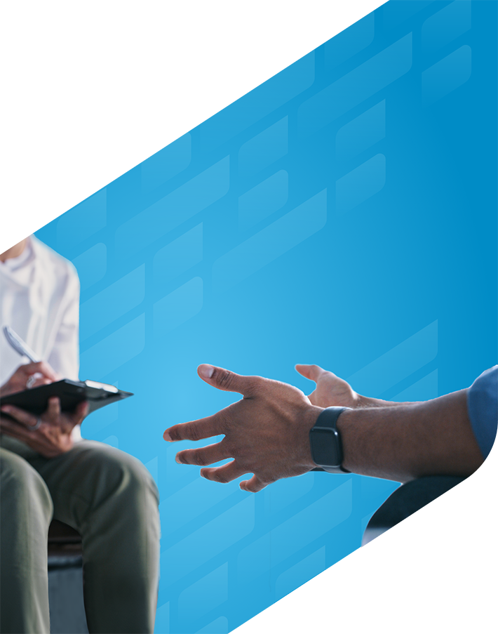 Close-up photo on patient hands while talking with healthcare provider taking notes on a clipboard
